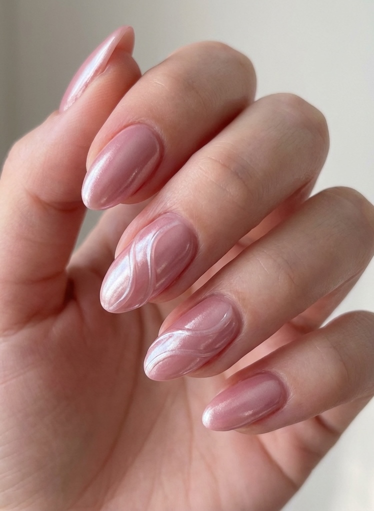Dusty rose nail art idea on mid-length nails, combining a metallic blush finish with smooth 3D swirl patterns that create soft texture on a glossy surface.