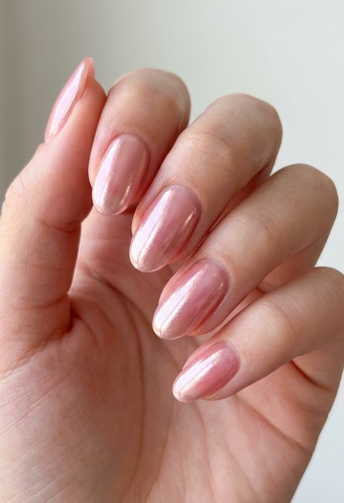 Natural nails with a glazed nail art idea in candy pink, coated in a luminous chrome shimmer for a glossy, lip-gloss-like effect.