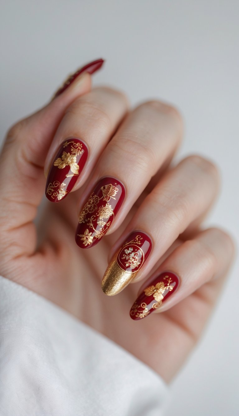 Fingers painted in rich wine red, each decorated with gold floral artwork and lunar motifs, including a single nail in full gold shimmer for symbolic impact