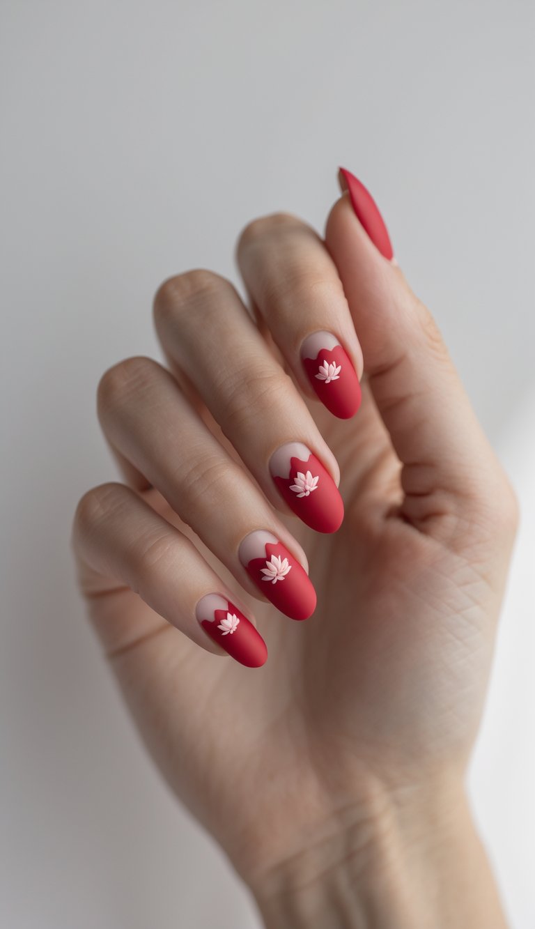 Hand with almond-shaped nails in matte red, each accented by a soft pink lotus flower and scalloped negative space tips, styled for Chinese New Year nail art idea.