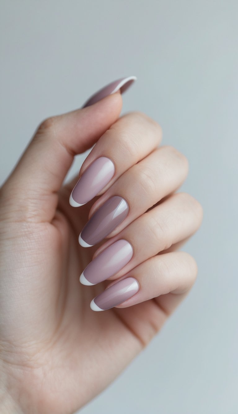Hand posed against a light background showing glossy mauve and blush nails with thin white French tips, captured as a minimalist Graduation Nail Art Idea.