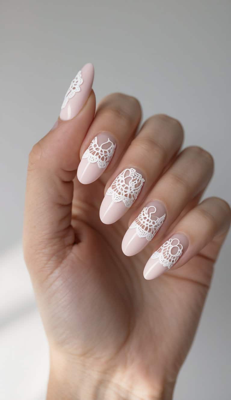 A soft pink manicure featuring white lace-like accents across five neatly manicured fingers—perfect for anyone seeking dreamy february nail art ideas with a bridal feel.