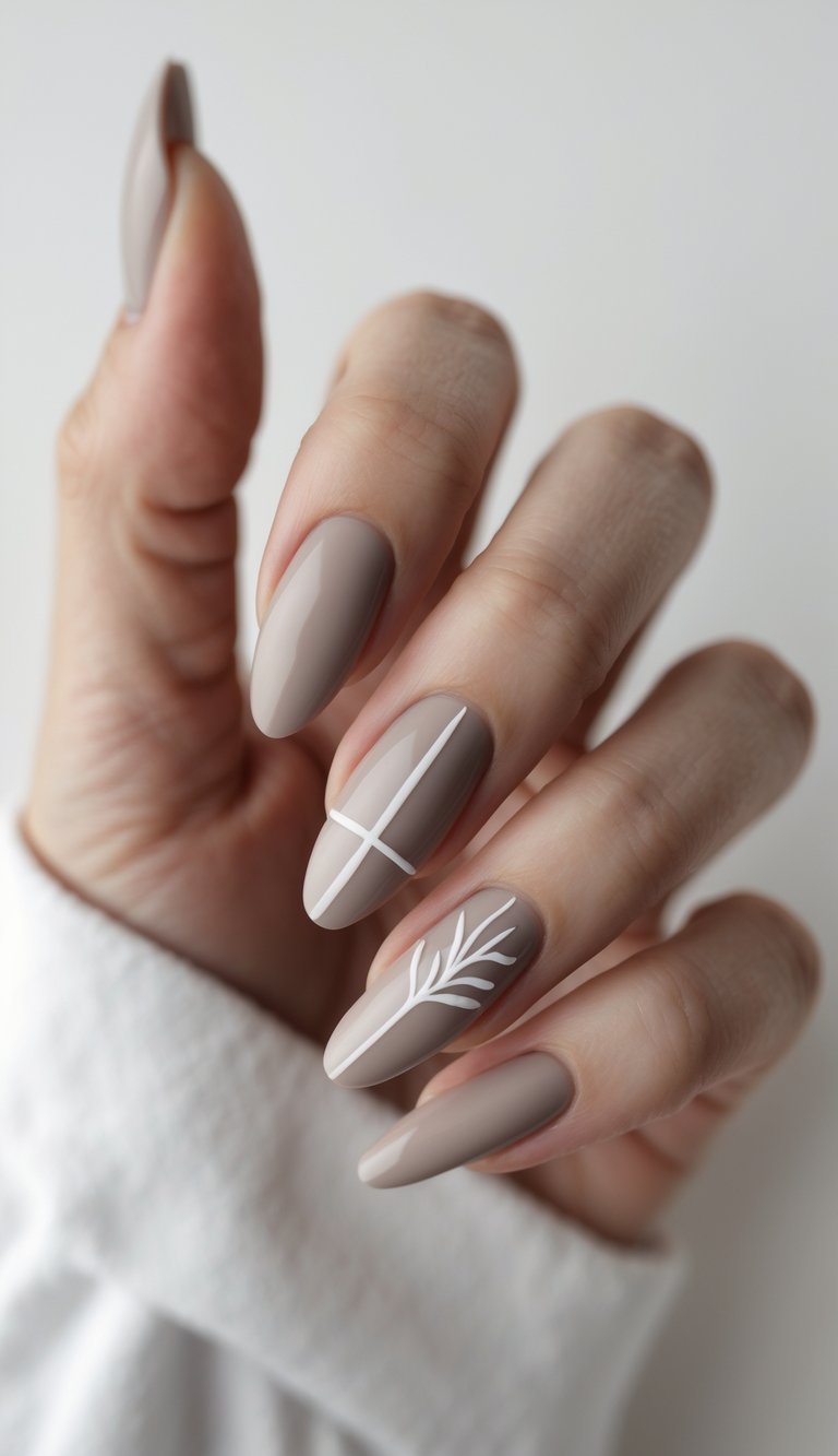 Feminine hand featuring glossy taupe nails, enhanced with white line art of a botanical sprig and minimalist cross, reflecting a clean girl nail art idea