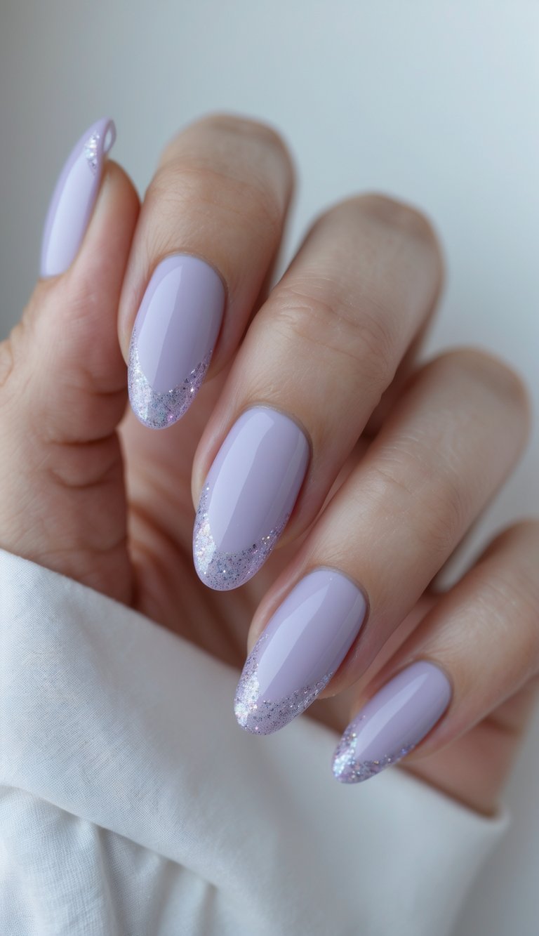 A hand featuring pastel lilac almond nails with fine glitter French tips, creating a clean and delicate nail art idea with a touch of shine.
