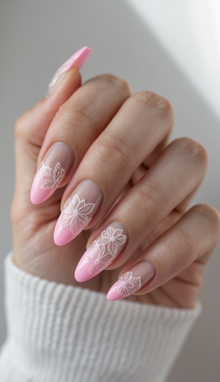 Close-up of one hand showing pink French tip nails with floral nail art on a white background.