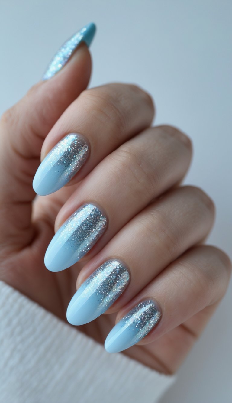 Close-up of a single hand with glittery silver and light blue ombré nails against a white background.