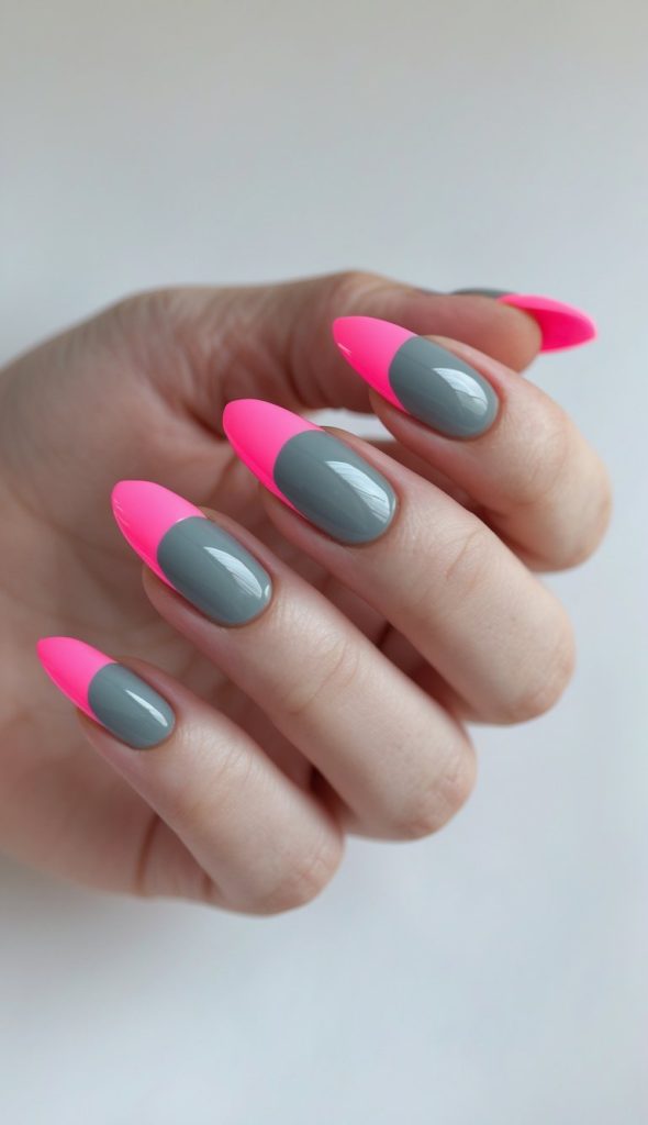 Angled photo of fingers wearing gray nails with neon pink tips, glossy finish, almond shape, and clean studio background illustrating a colored French nail art idea.