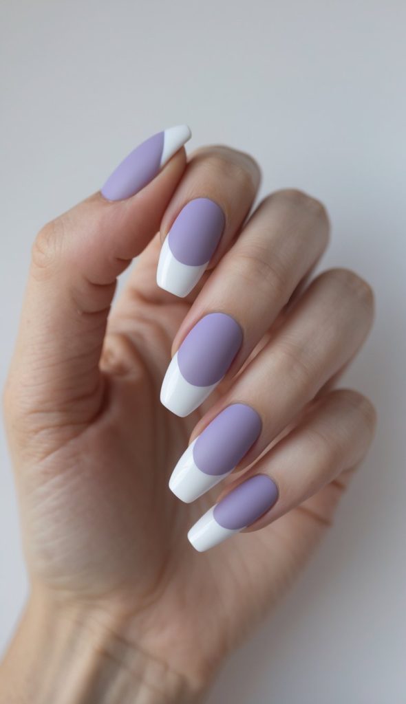 Lavender nails with glossy polish and solid white French tips, showing a colored French nail art idea with rounded color placement and a clean, minimal design.