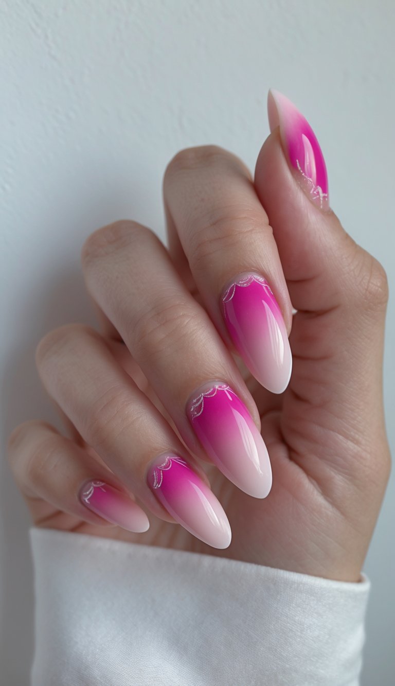 A hand with almond-shaped nails features a fuchsia nail art idea with seamless ombré fading from hot pink to blush, topped with silver scalloped linework near the base.