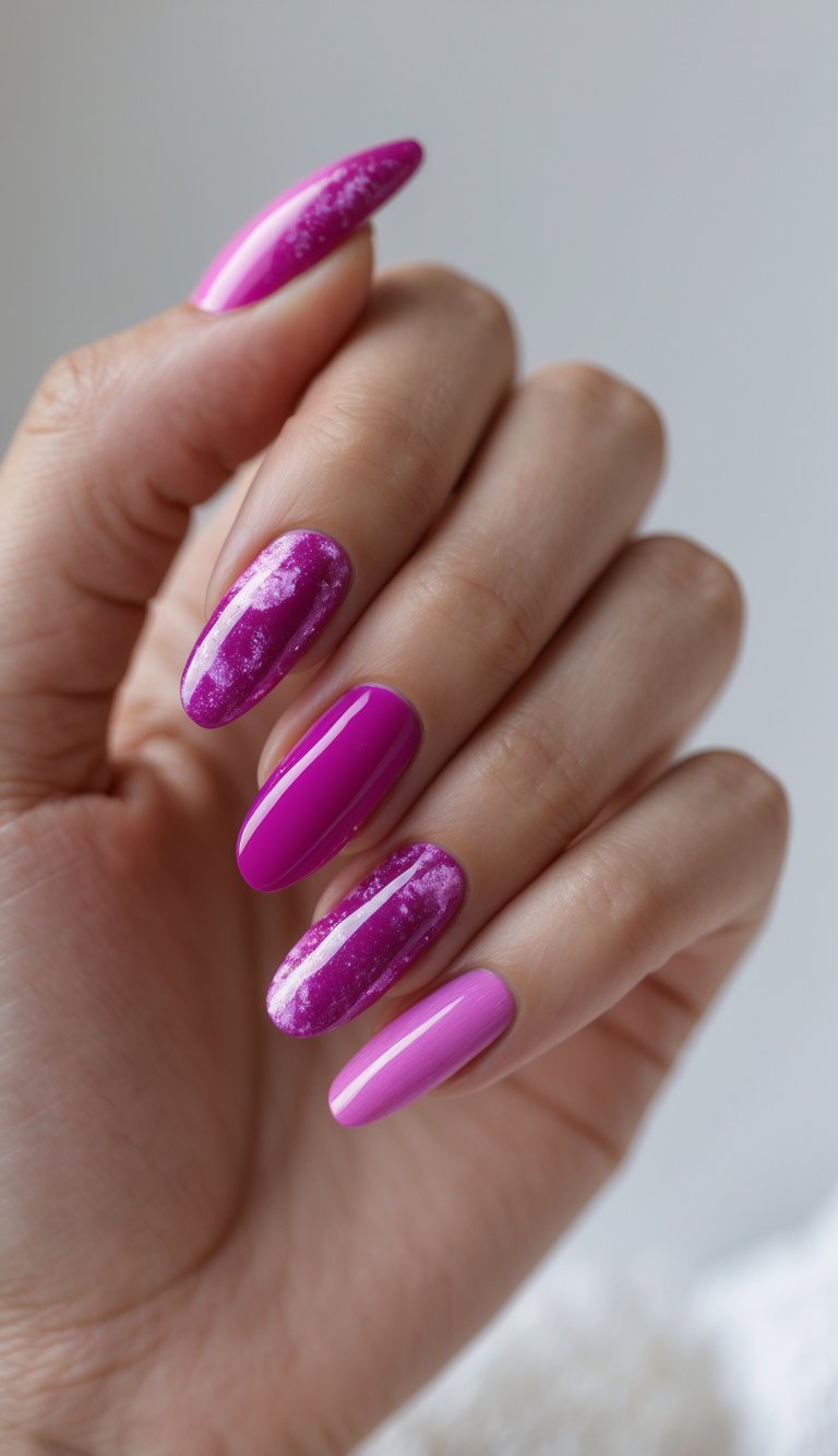 Close-up of a hand with fuchsia nail art, showcasing a mix of glossy and marbled galaxy-like accents for a celestial nail design.