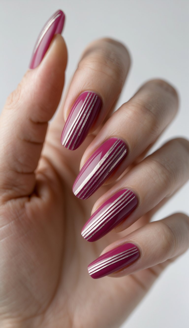 Hand posed gently to reveal a raspberry nail art idea featuring glossy raspberry nails detailed with precise silver pinstripes placed vertically along each nail.