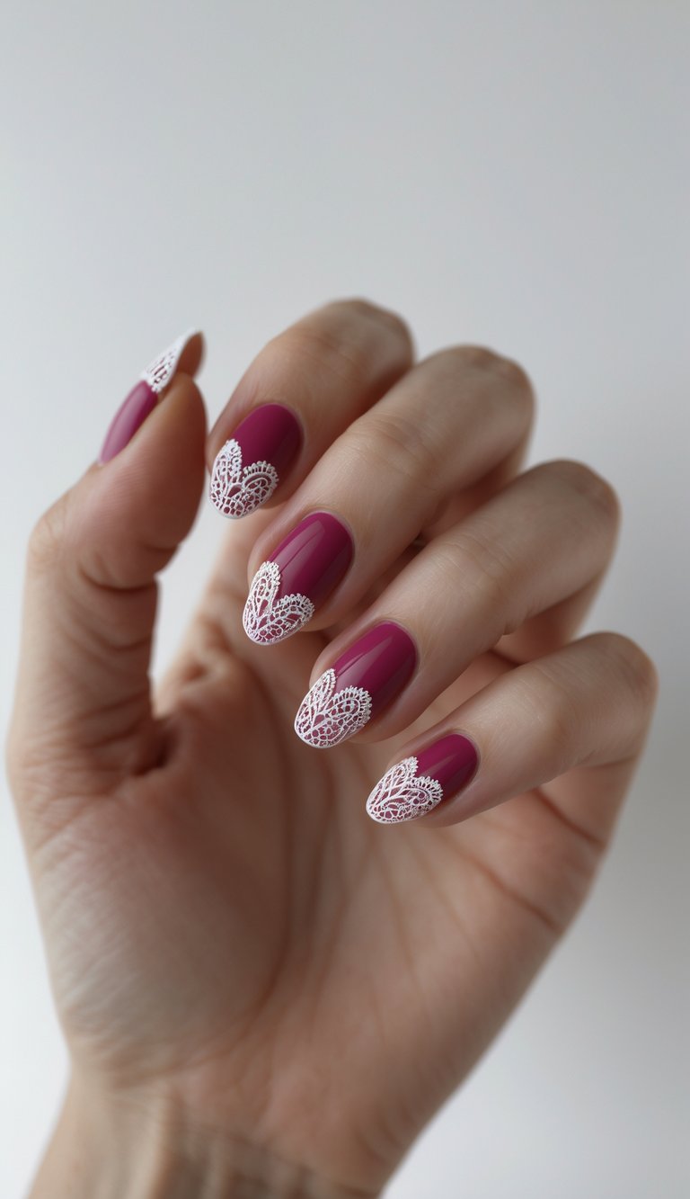 Manicured fingers posed gently, displaying raspberry-toned nails accented with delicate white lace patterns layered over the nail tips.