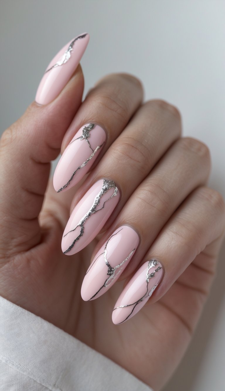 Close-up of one hand with pink marble nails and silver veining on a white background.