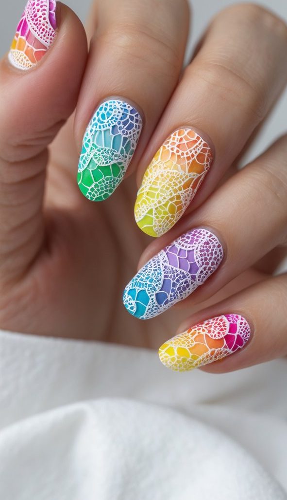 Stylish rainbow nail art idea on oval nails with modern lace stamping over gradient polish in red, green, purple, blue, and yellow hues.