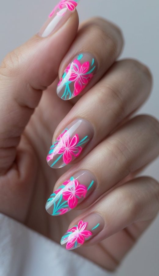 Fingertips with semi-transparent nails decorated in a floral nail art idea with bold neon pink flowers and bright blue leafy details.