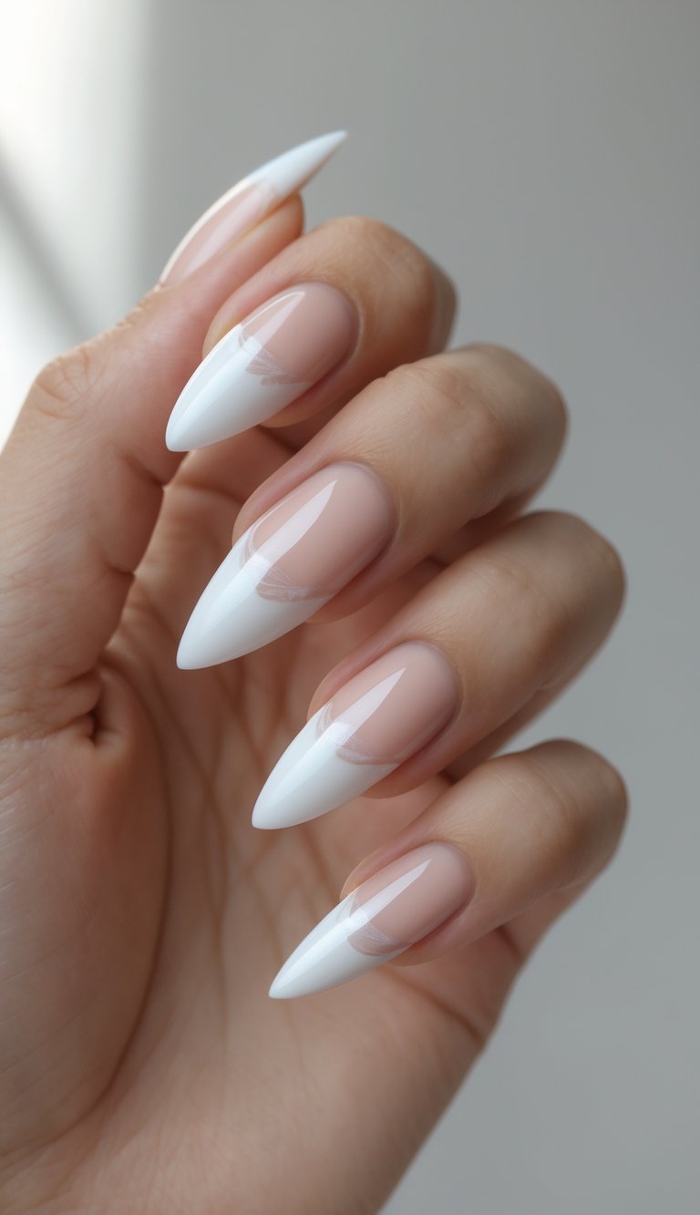 Stiletto nail art idea combining glossy nude polish and sharply pointed white tips for a sleek minimalist manicure