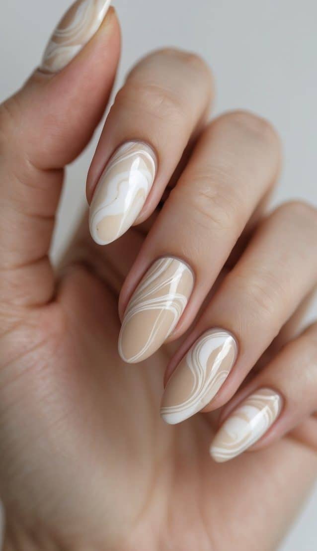 Close-up of hands with softly blended nude and white swirl nail art, presenting sophisticated march nail art ideas in minimalist style.