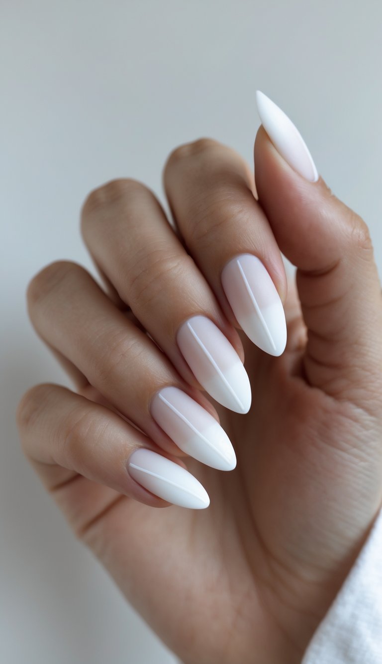 Close-up of sleek almond nails featuring a white French tip nail art idea with curved bright tips and a subtle, clear-pink base