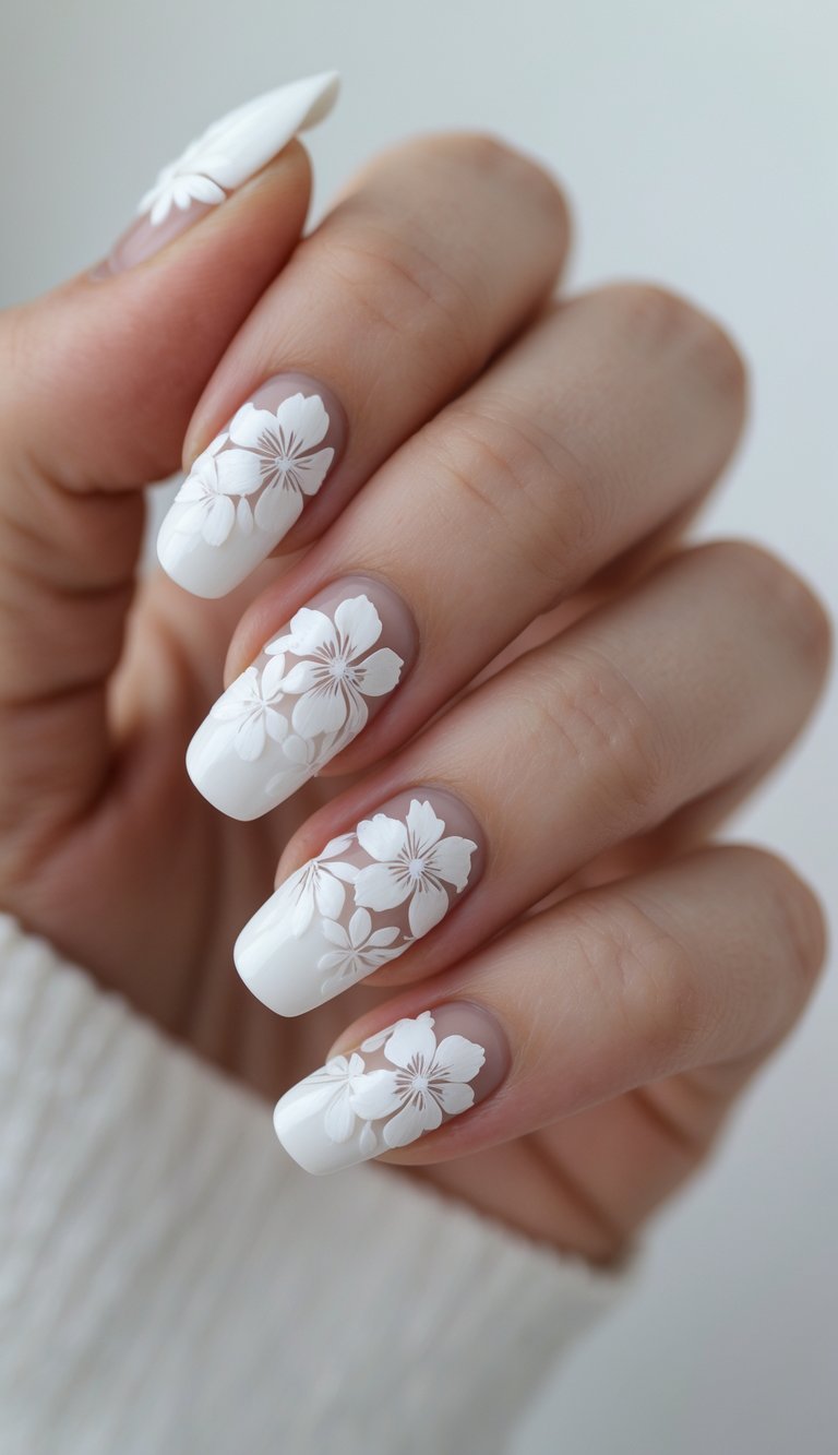 Feminine hand with squared white French tip nail art idea, featuring large white flower patterns over a nude base for a fresh, standout design