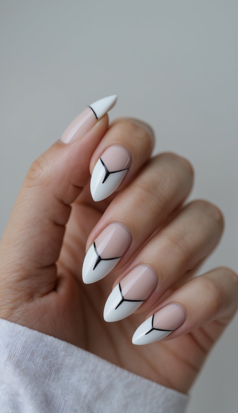 Hand with almond nails featuring a white French tip nail art idea outlined with black geometric lines forming a Y-shape at each tip