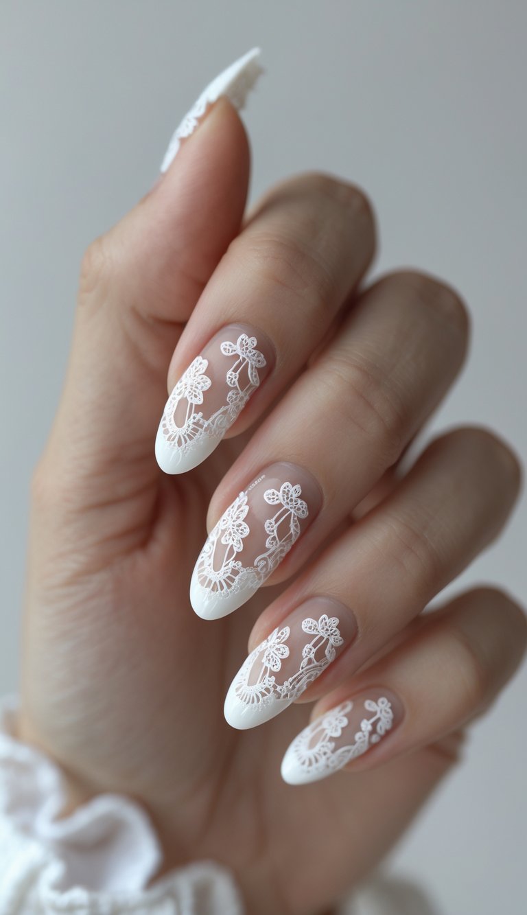 Hand with almond-shaped nails showing a white French tip nail art idea decorated with intricate white lace and floral detailing over a sheer base