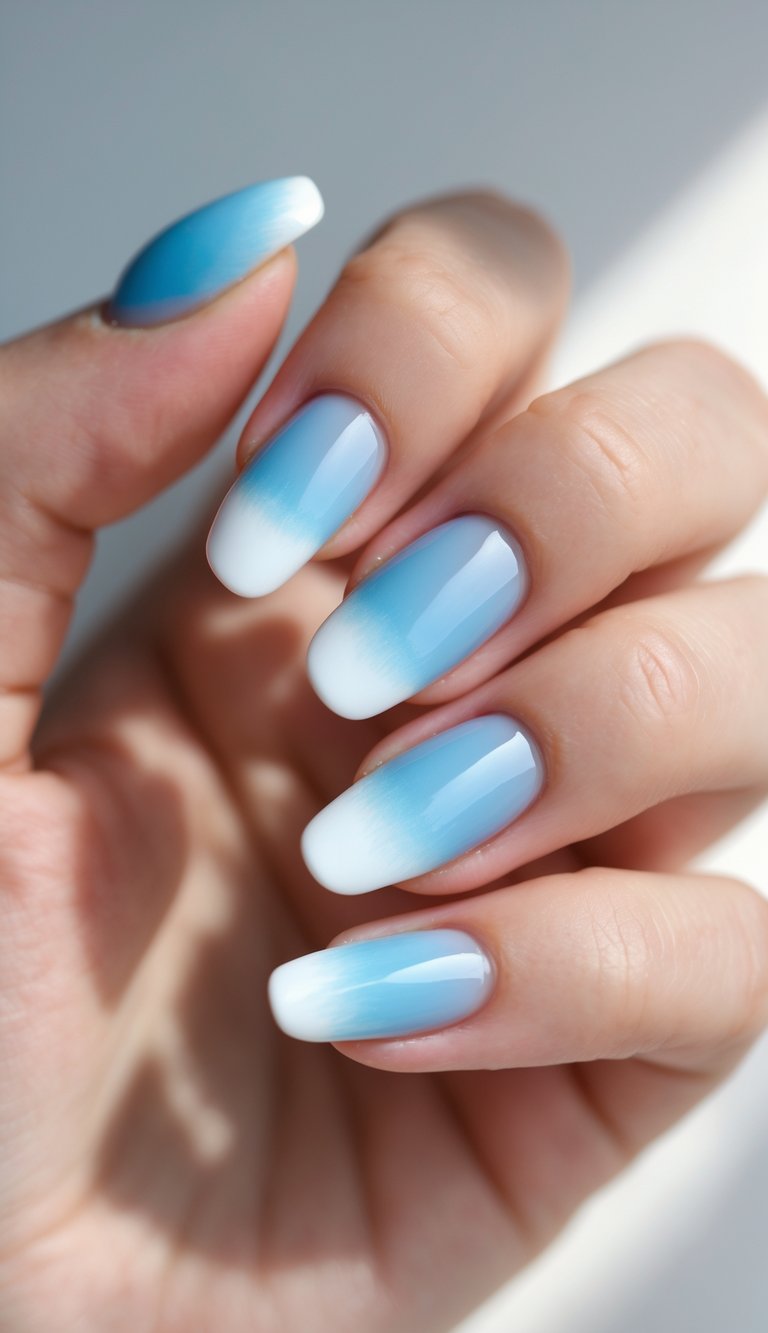 Close-up of almond-shaped nails showcasing a soft transition from white French tips to pale sky blue polish
