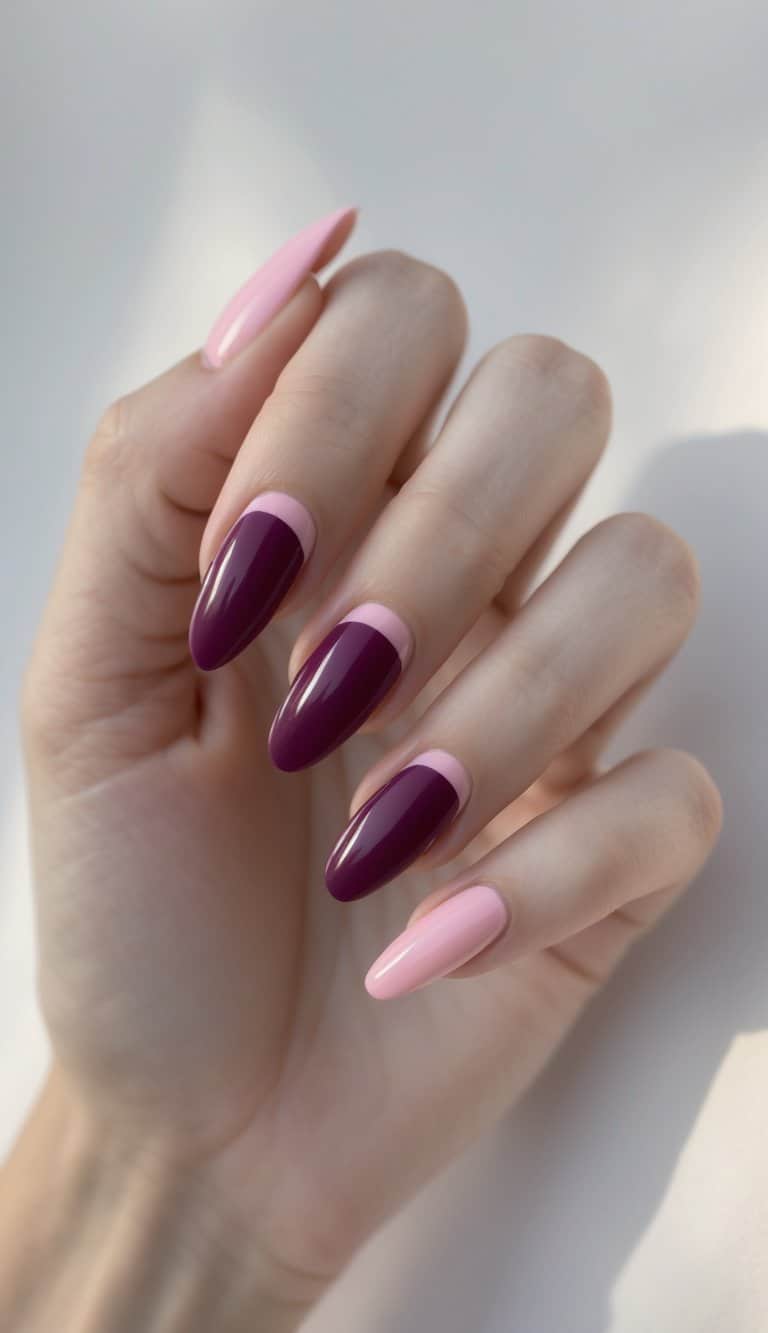 A hand is shown with almond-shaped nails alternating between rich plum polish and pale pink shades, finished with a smooth, high-gloss surface.