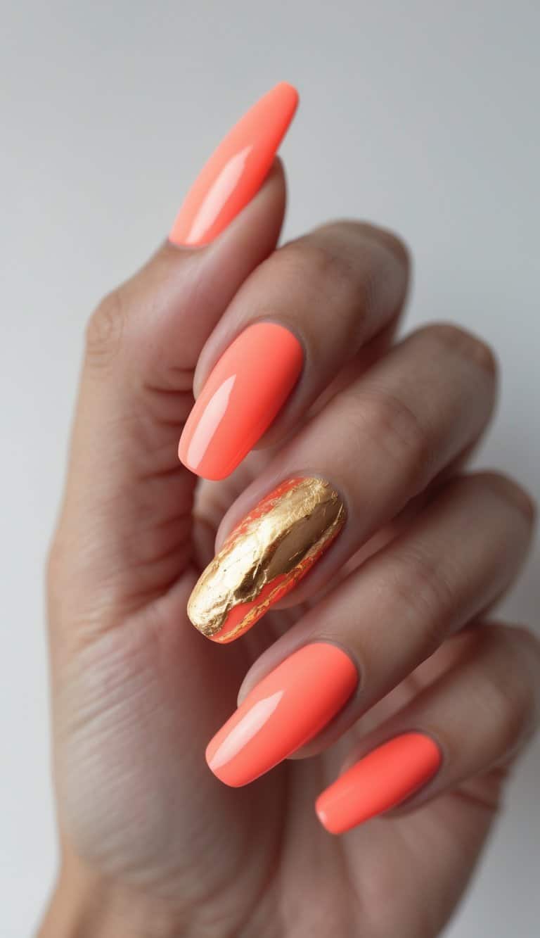 Photographed from a side angle, a hand displays glossy coral nails with a textured gold foil accent, showcasing a dramatic two tone nail art idea.
