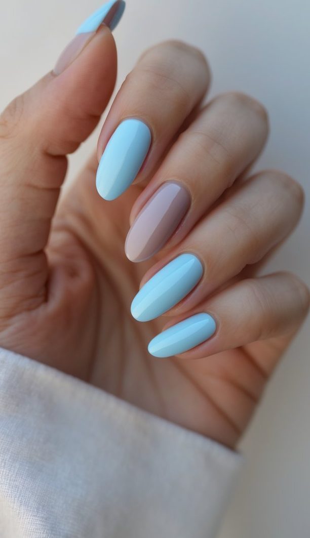 Glossy dusty rose nail art idea featuring almond-shaped nails with four painted in pastel blue and one muted rose-mauve accent nail for a clean, modern contrast.
