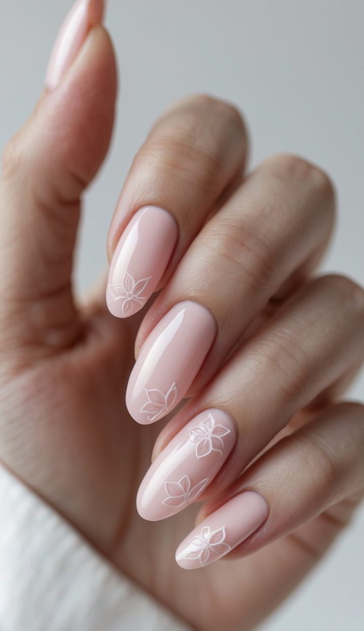 Glossy pink nails on a hand, decorated with white outlined floral patterns for a chic and fresh glossy nail art idea.