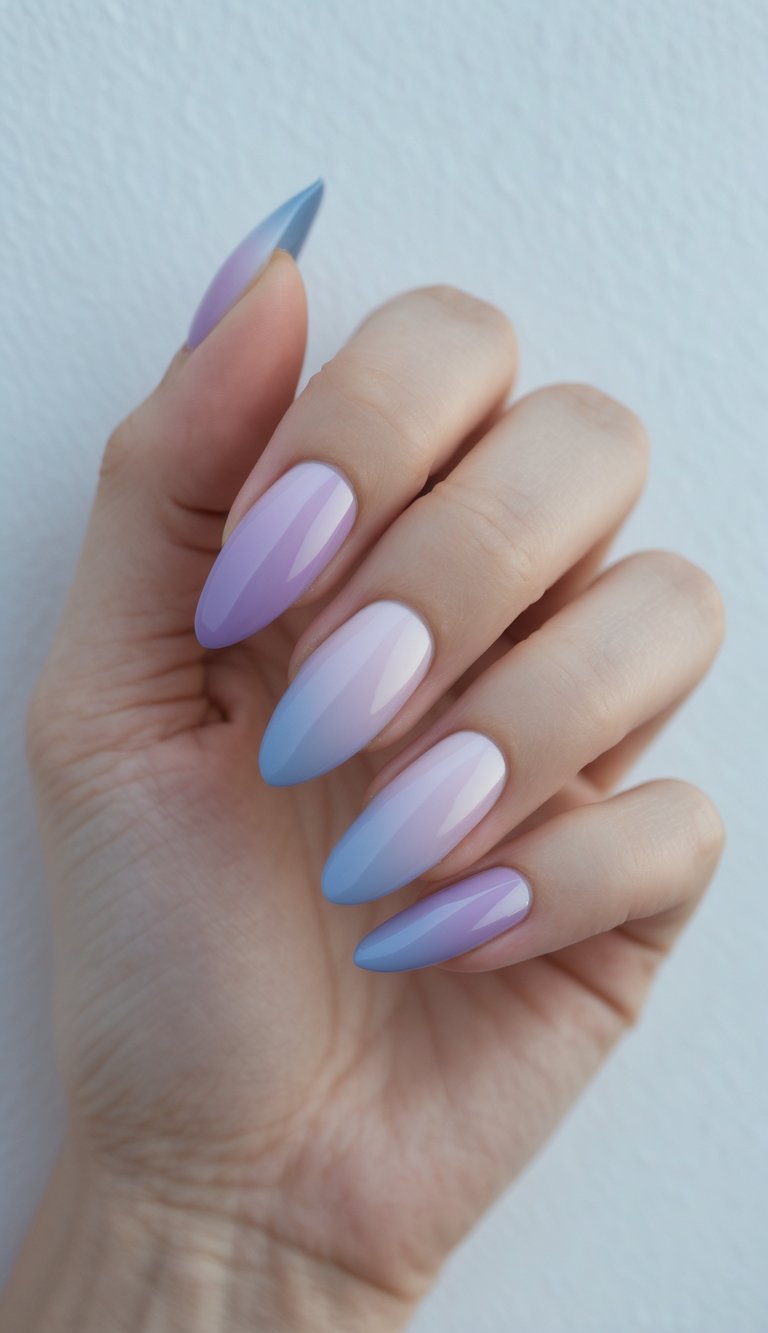 What happens when lilac dreams meet cool skies? A hand showing off almond nails with a striking ombre French nail art idea in purple and blue hues.