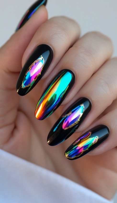 Manicure featuring foil nail art idea with rainbow foil strips layered over glossy black nails, framed by gold foil for a luxe finish.