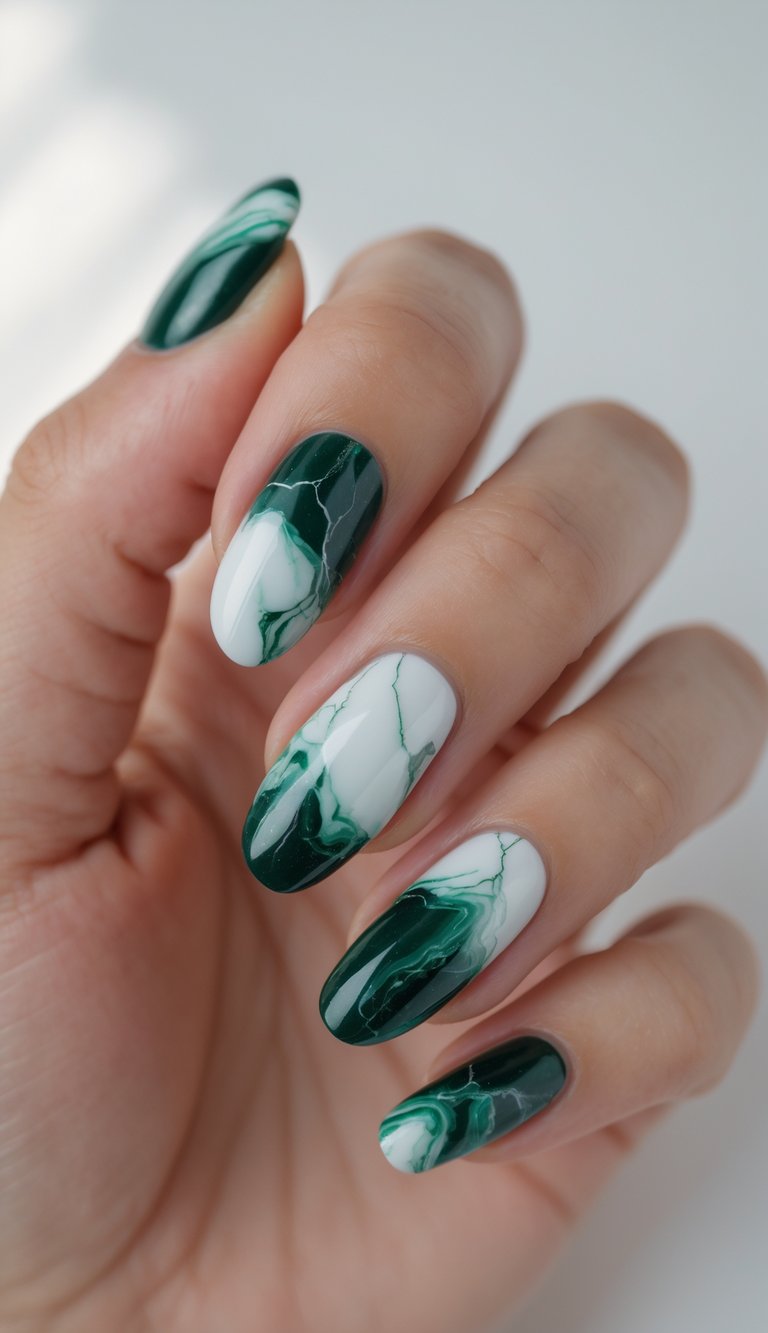 A softly lit hand showing almond nails with a marble nail art idea in swirling pine green and white, creating a natural, stone-like effect with a glassy sheen
