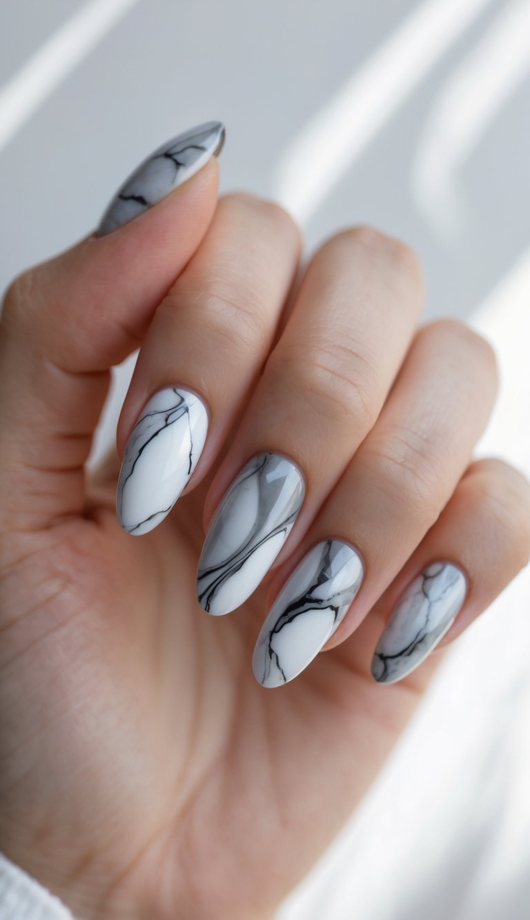 Elegant marble nails with white and gray base tones and natural-looking black veining—an artful, graceful marble nail art idea