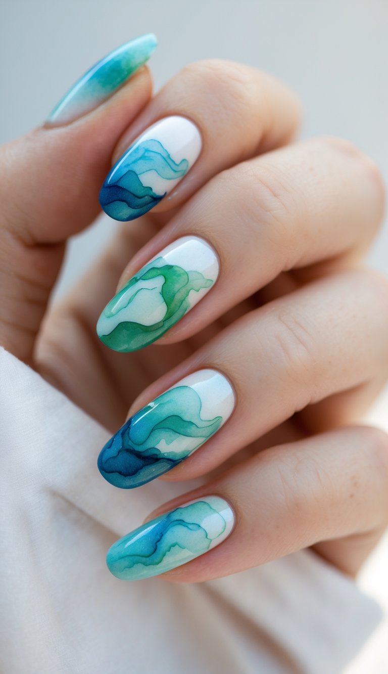 Almond-shaped nails resembling ocean currents in layered shades of teal and sapphire on a bright base, evoking a flowing watercolor nail art idea.