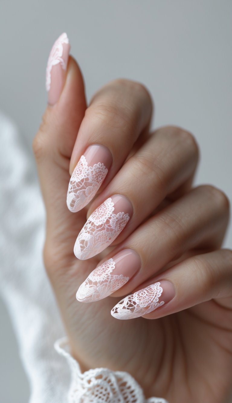 Close-up of feminine hand wearing a lace nail art idea with fine white lace designs layered over a sheer pink background on almond-shaped nails.