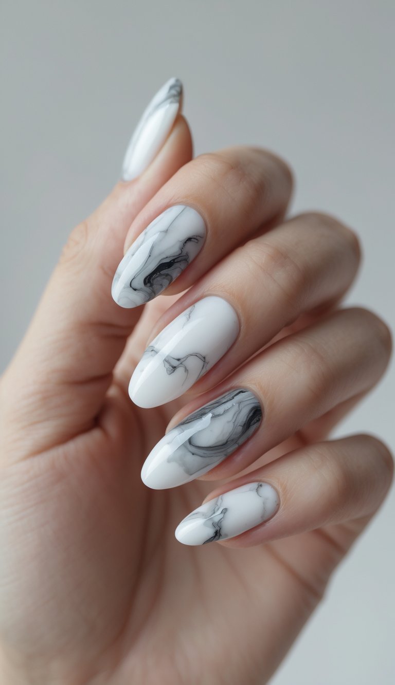 Hand with long oval nails designed with a smoky gray and black marble pattern over a white background, perfect for a refined oval nail art idea.