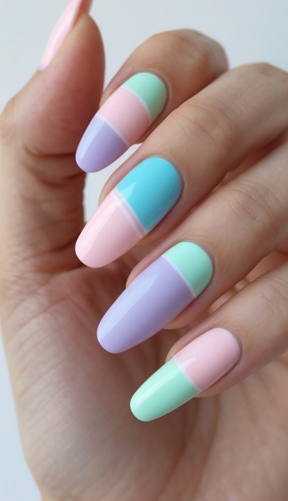 Close-up of fingers wearing a mix and match nail art idea with glossy pastel color blocks in mint green, lilac, blue, and pink on each nail.