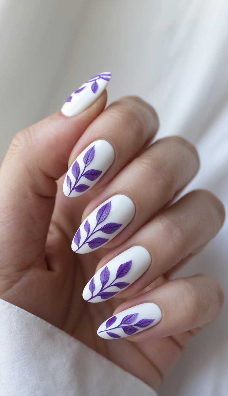 An angled view of almond-shaped white nails featuring hand-painted purple leaf motifs, presenting a refined purple and white nail art idea.