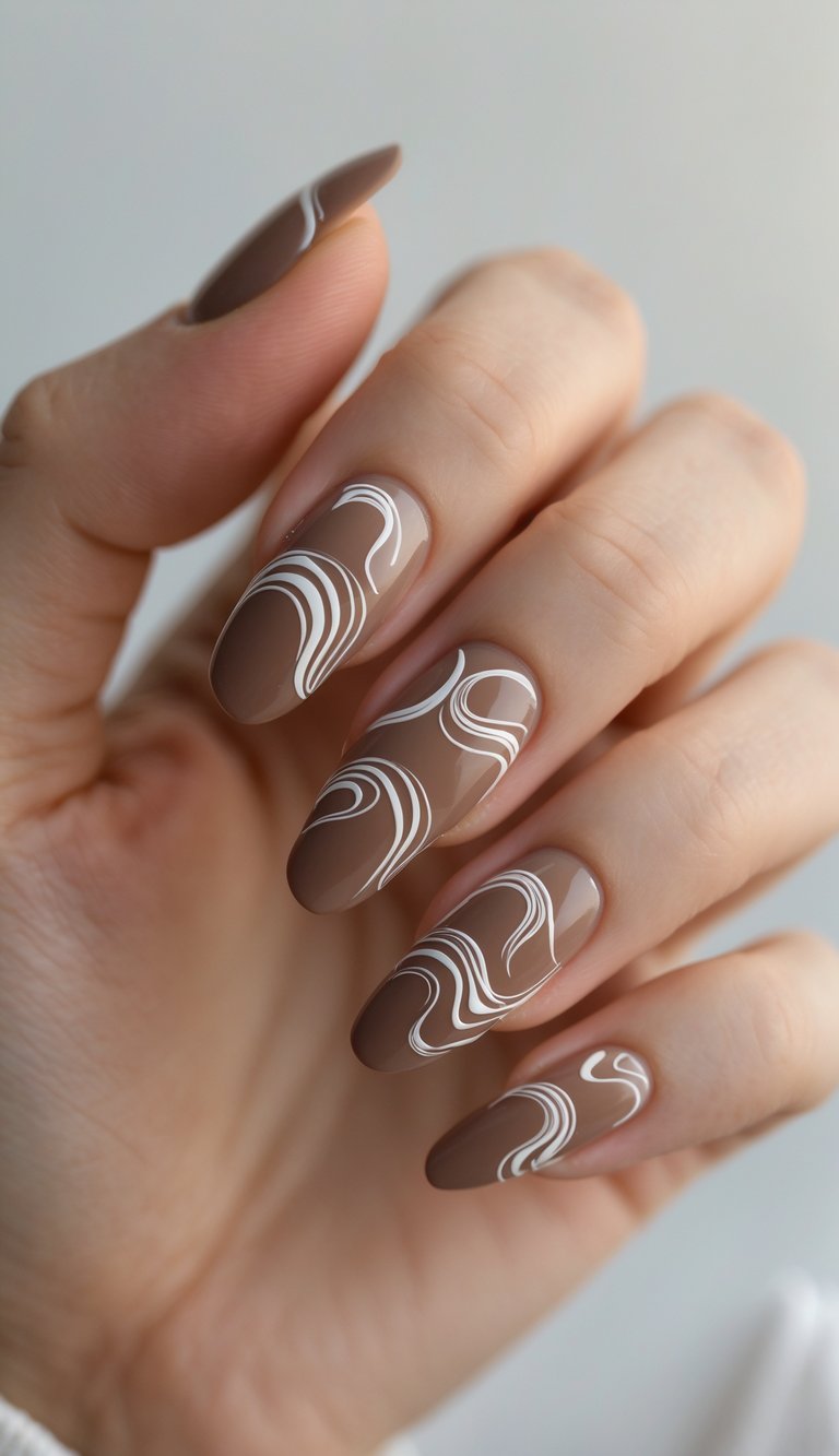 Close-up of one hand with mocha-colored nails featuring abstract swirl designs against a white background.