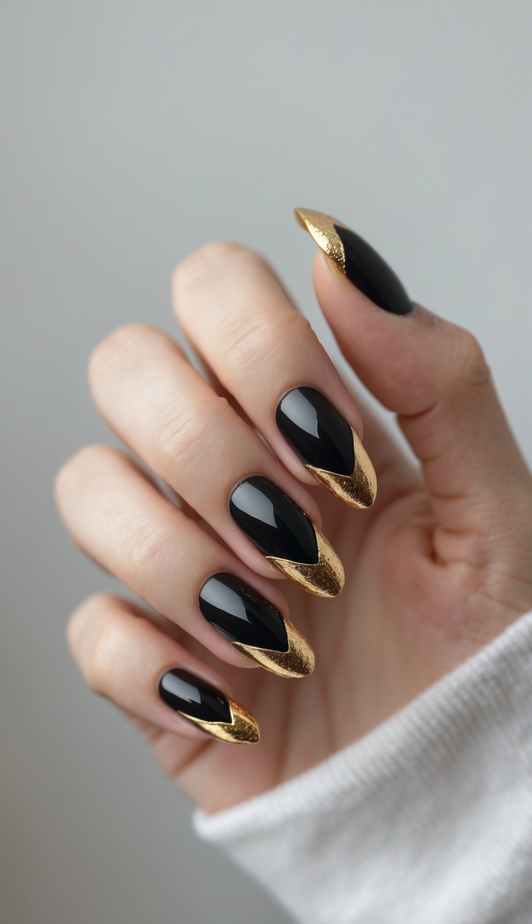 Close-up of one hand with black nails featuring gold leaf tips against a white background.