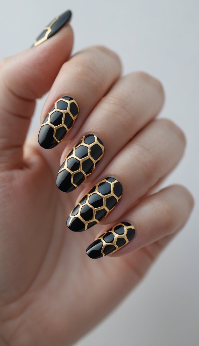 Close-up of one hand with black nails decorated with a gold honeycomb pattern against a white background.