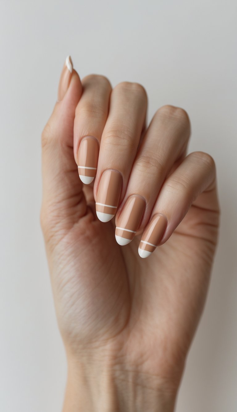 Close-up of a single hand with soft caramel-colored nails decorated with tiny white stripes against a white background.