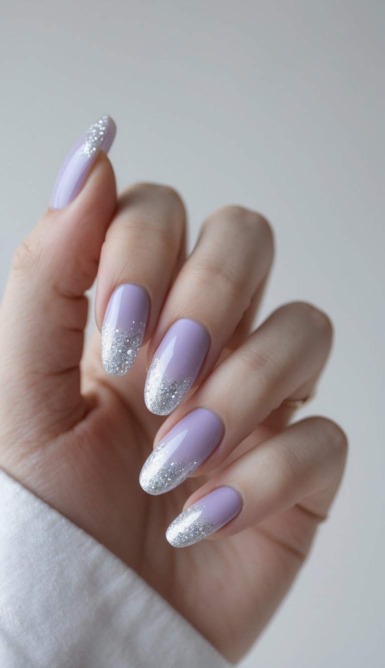 Close-up of a single hand with light purple nails featuring a silver glitter gradient on a white background.