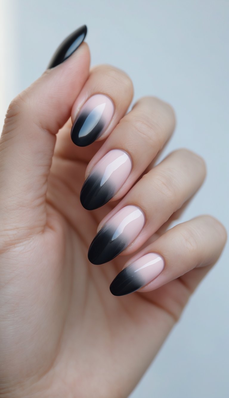Close-up of one hand with black nails fading into pale pink tips against a white background.