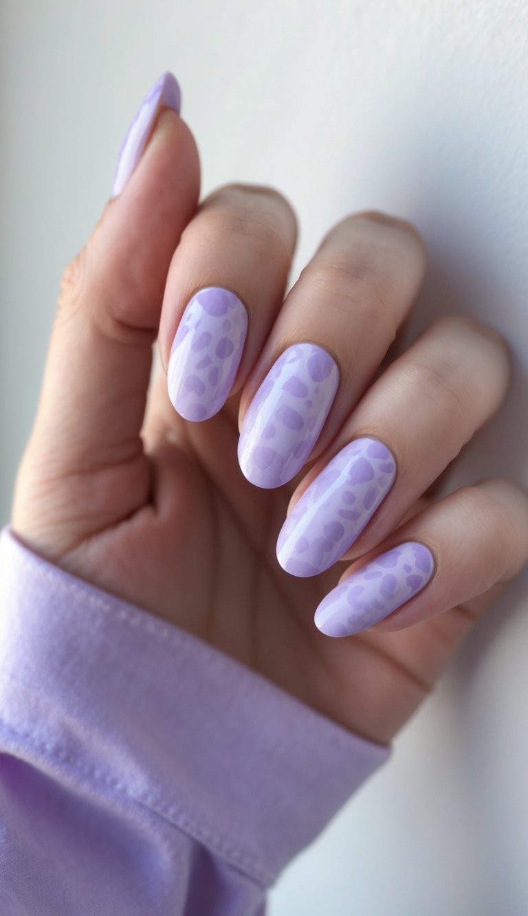 Close-up of one hand with nails painted in soft lavender animal print designs against a white background.