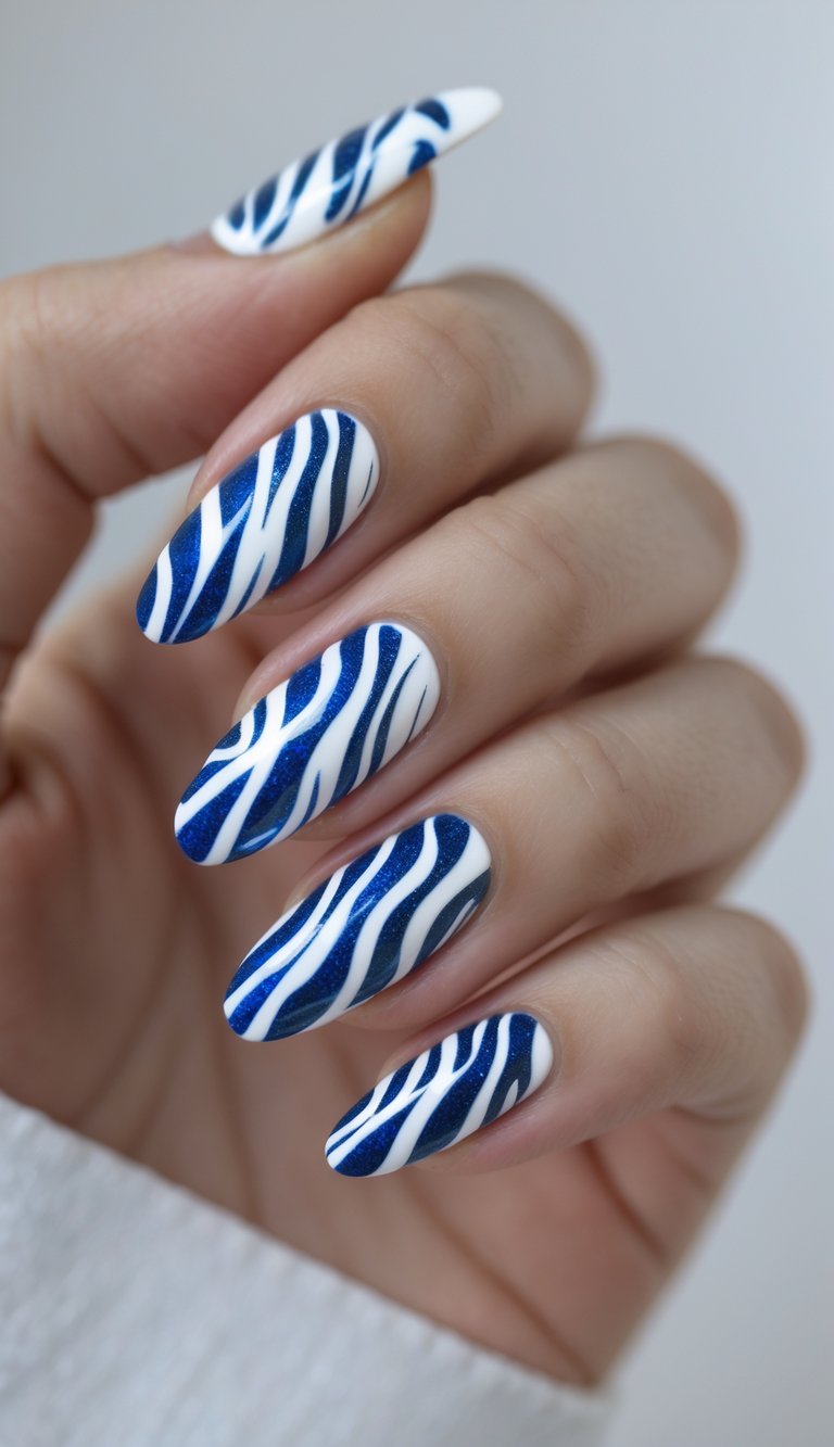 Close-up of one hand with blue and white zebra print nail art on all nails against a white background.