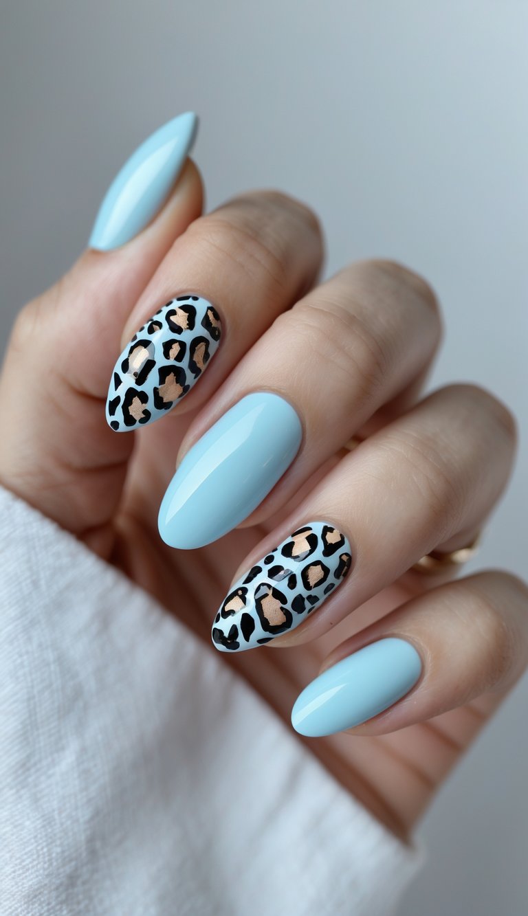 Close-up of one hand showing pastel blue nails with black leopard print accents against a white background.