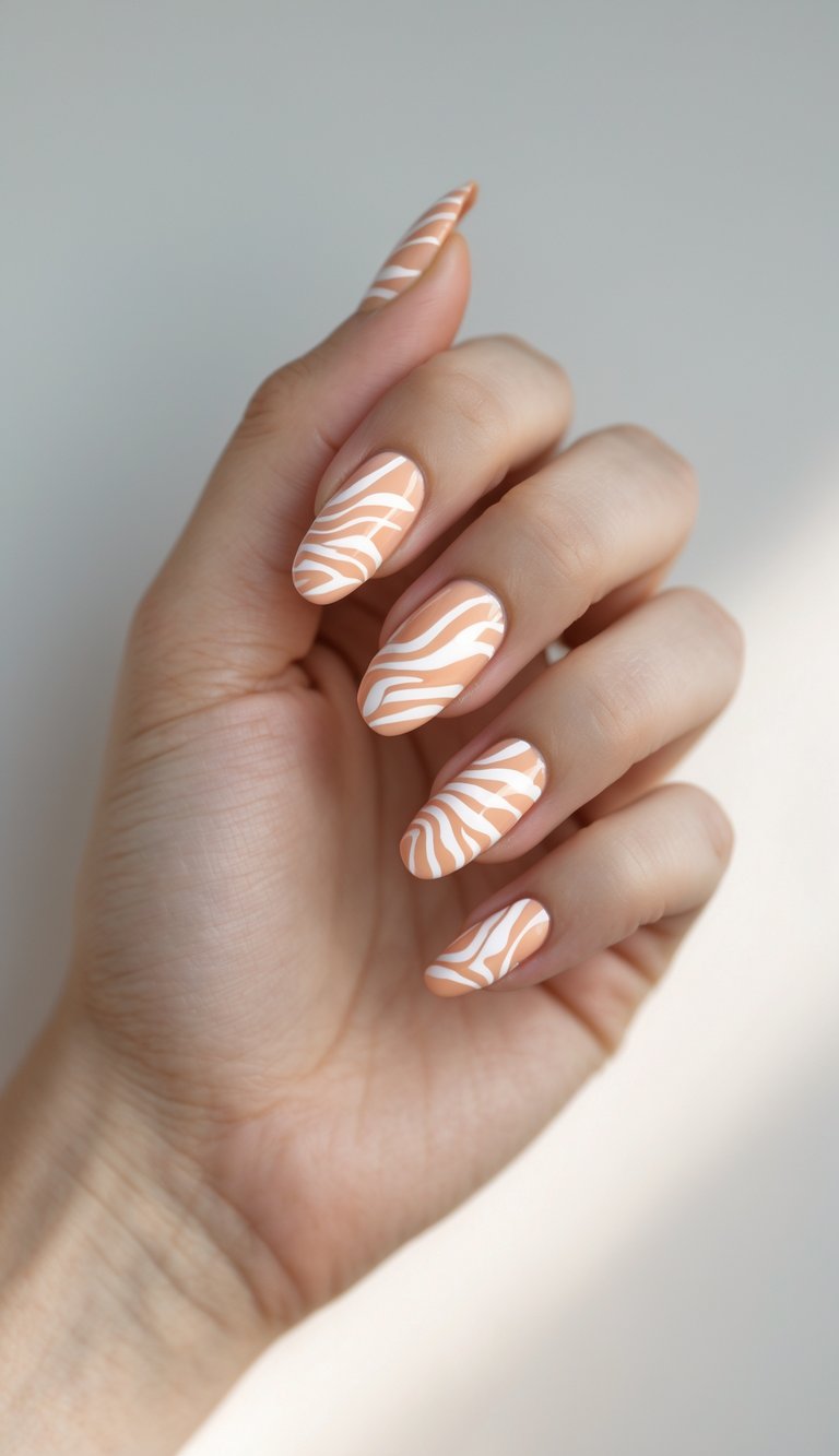 Close-up of a single hand with peach-colored nails featuring white zebra stripe designs on a white background.