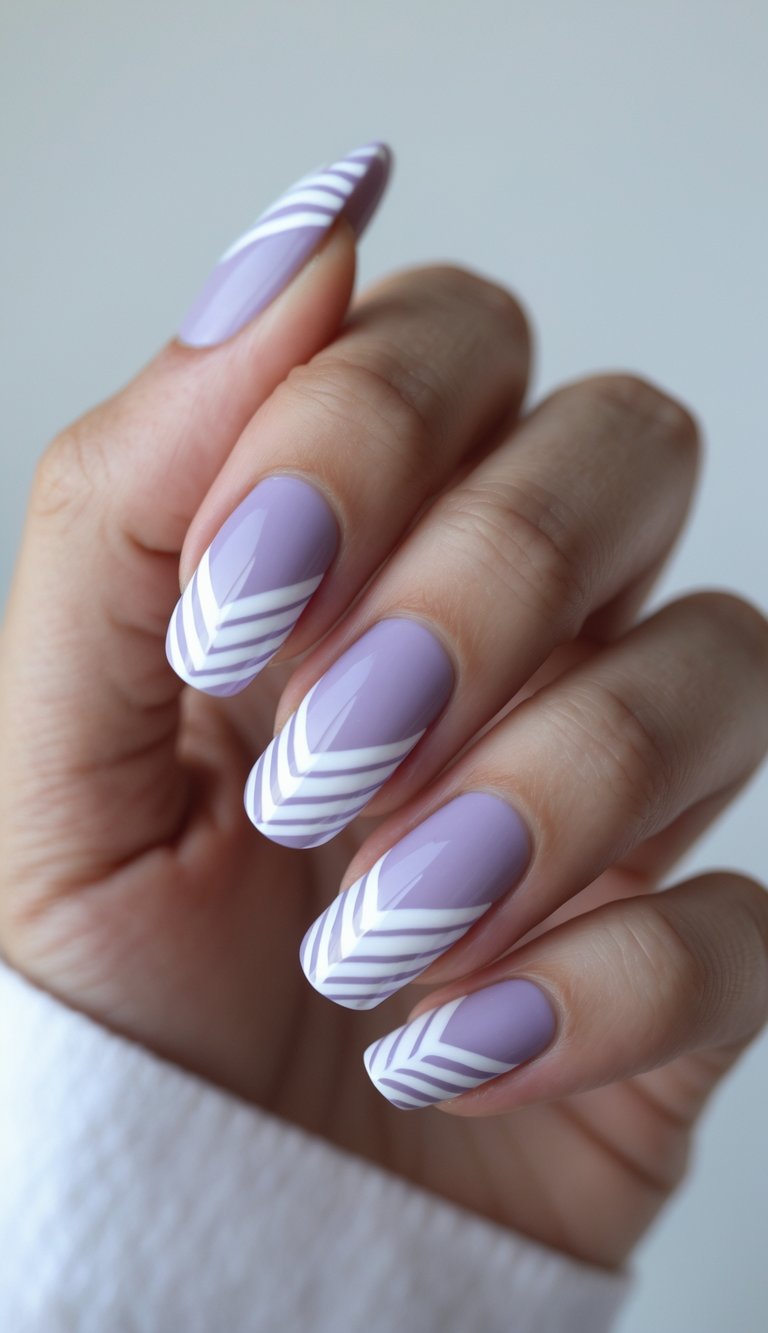 Close-up of a hand with lavender nails featuring white chevron patterns against a white background.